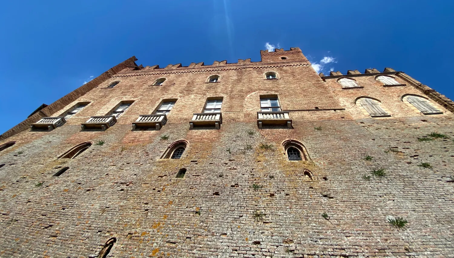 Castello di Montemagno Monferrato seen from below with pointed-arch windows and a hilltop setting.